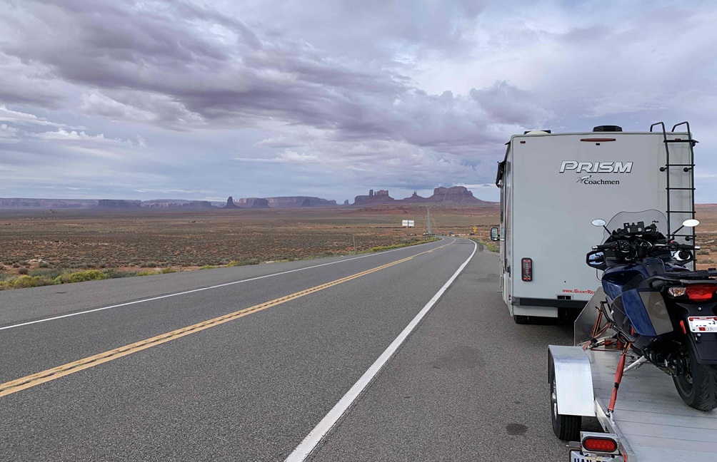 Coachmen Prism RV and Triumph motorcycle in Monument Valley